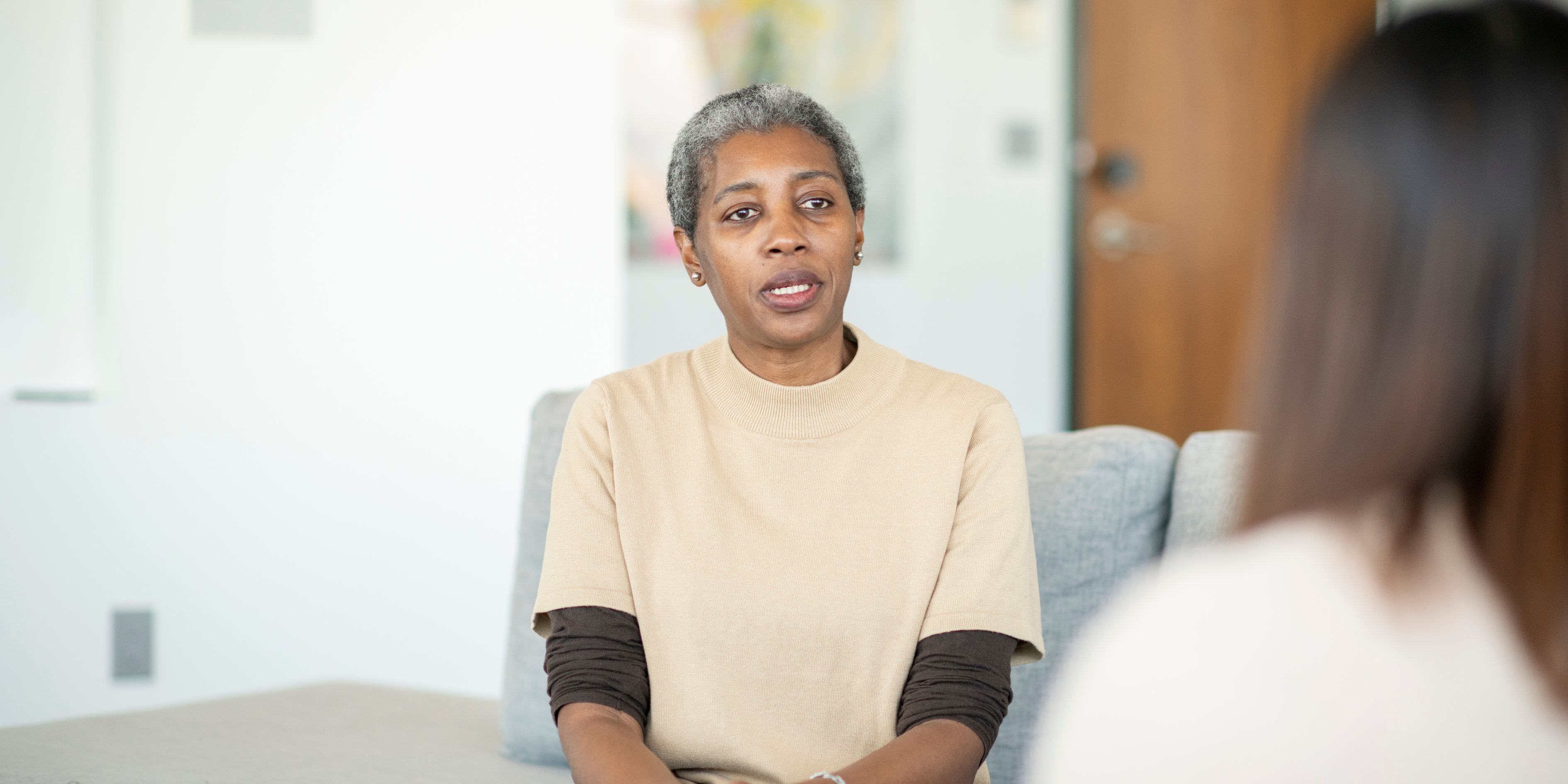 Dr. Mande Scheepmaker consulting with a patient at her desk, offering personalized homeopathic and functional medicine care.